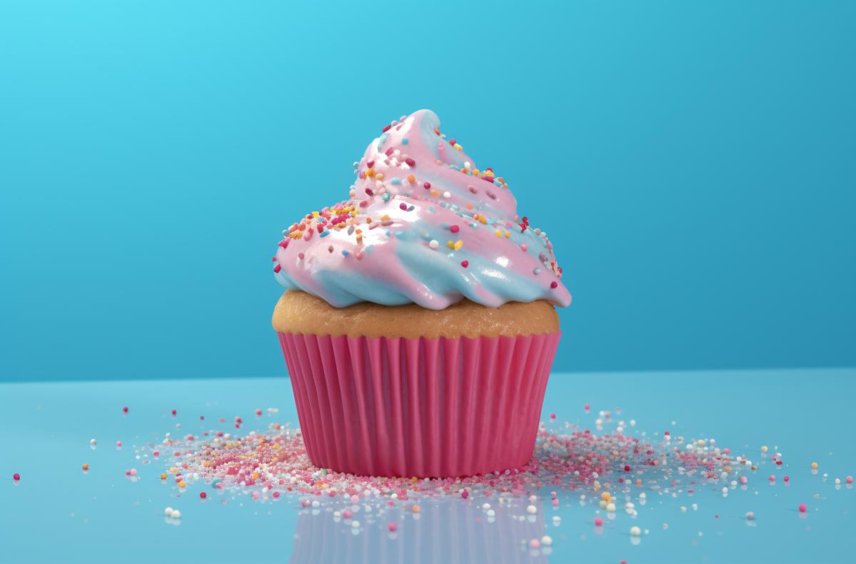 cupcake on table on blue surface with sprinkles picture